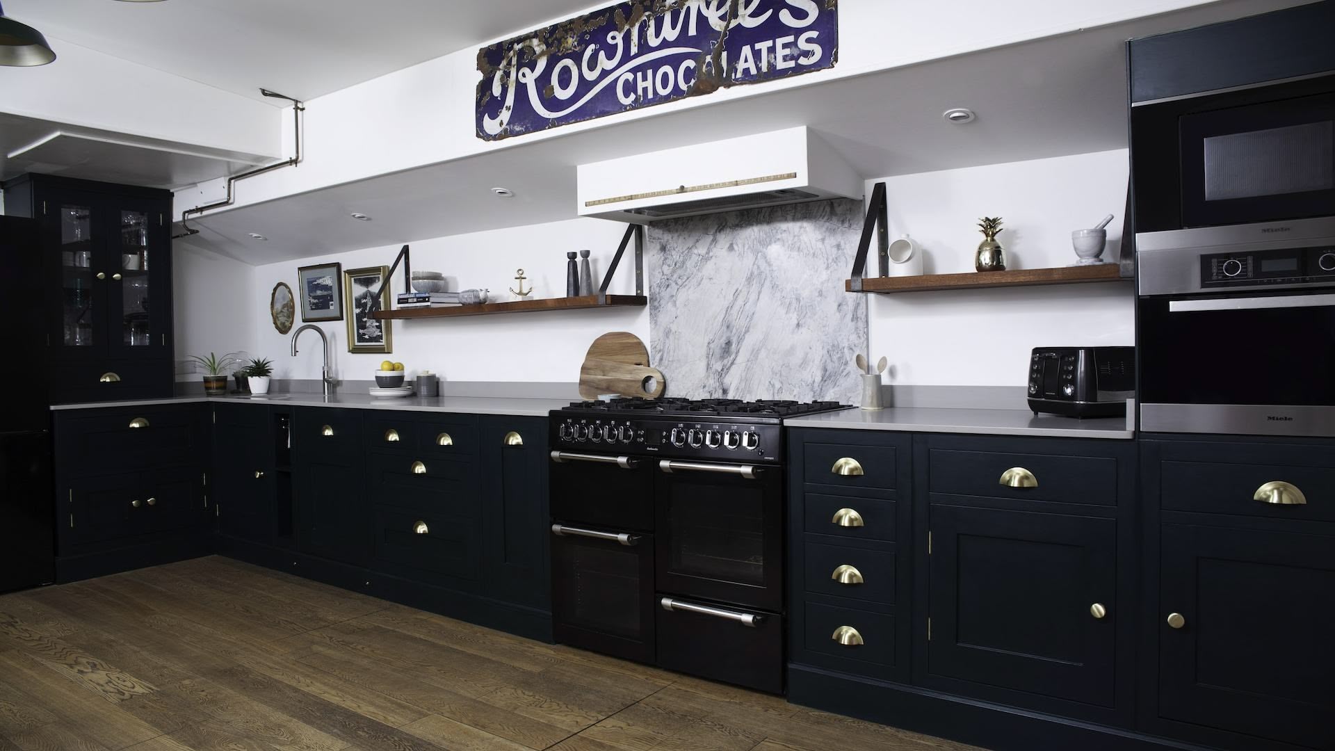 Rich green Shaker kitchen cabinetry and grey worktops