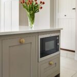 Beige Shaker kitchen island with natural wood handles and integrated microwave