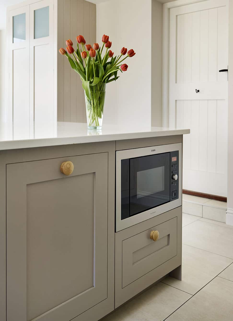 Beige Shaker kitchen island with natural wood handles and integrated microwave