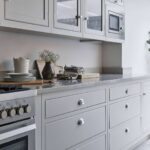 White Arbor kitchen cabinetry with white worktop alongside a cooker