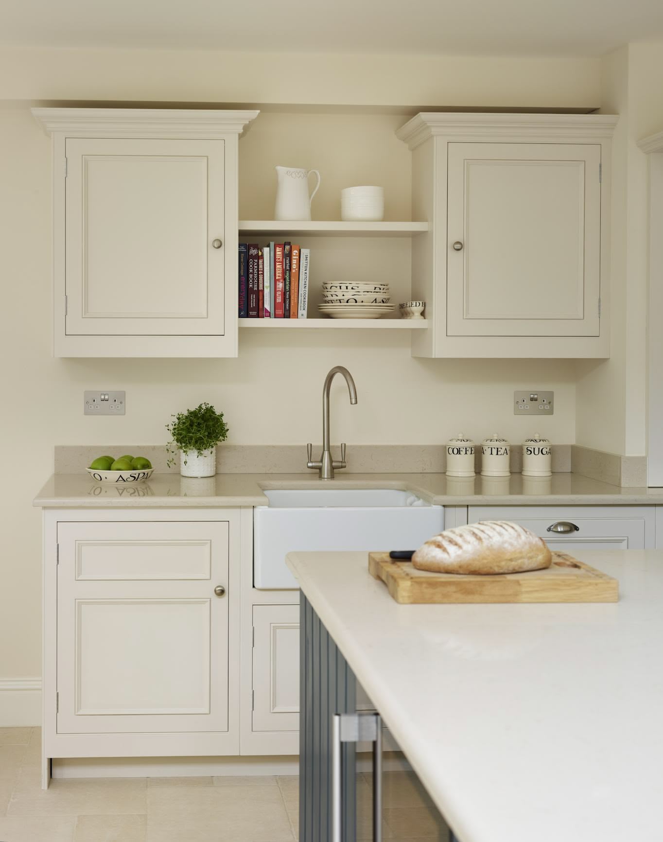 Cream kitchen cabinetry with white sink and silver tap