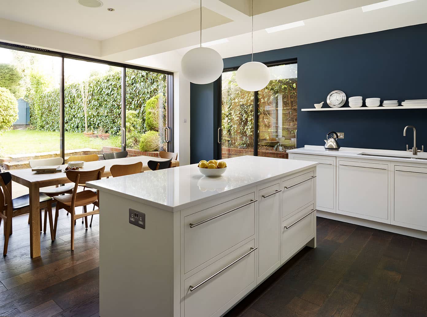 Low level kitchen design with white cabinetry and open plan dining area
