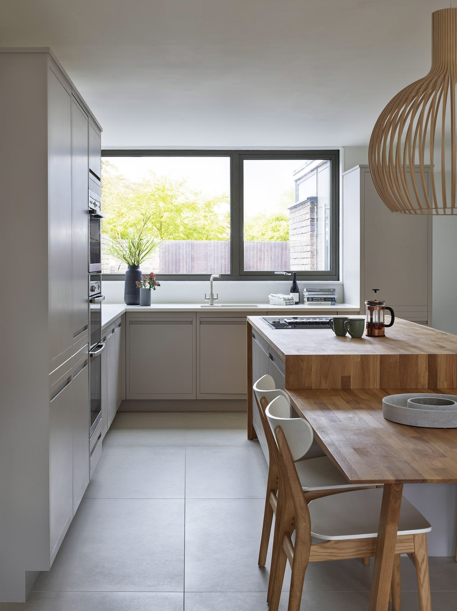 Natural beige Linear Edge kitchen cabinetry and wooden kitchen island with open plan dining area