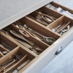 Grey kitchen drawer with walnut interior open to show organised cutlery storage