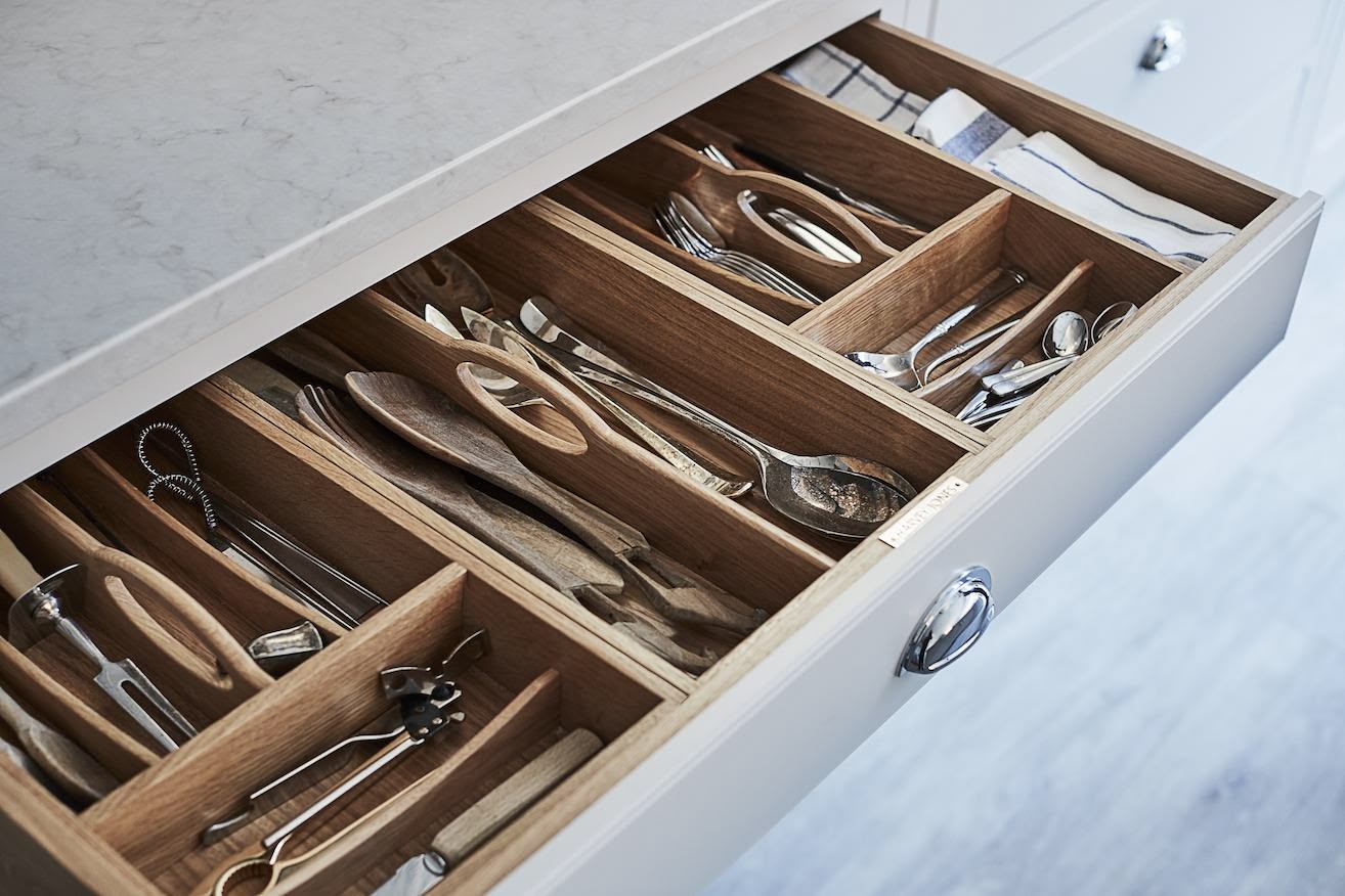 Grey kitchen drawer with walnut interior open to show organised cutlery storage