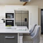 Grey kitchen island with which worktop and soft grey chairs