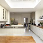 Broken plan Shaker kitchen design featuring white Shaker cabinetry