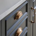 Closeup of dark kitchen drawers with copper handles