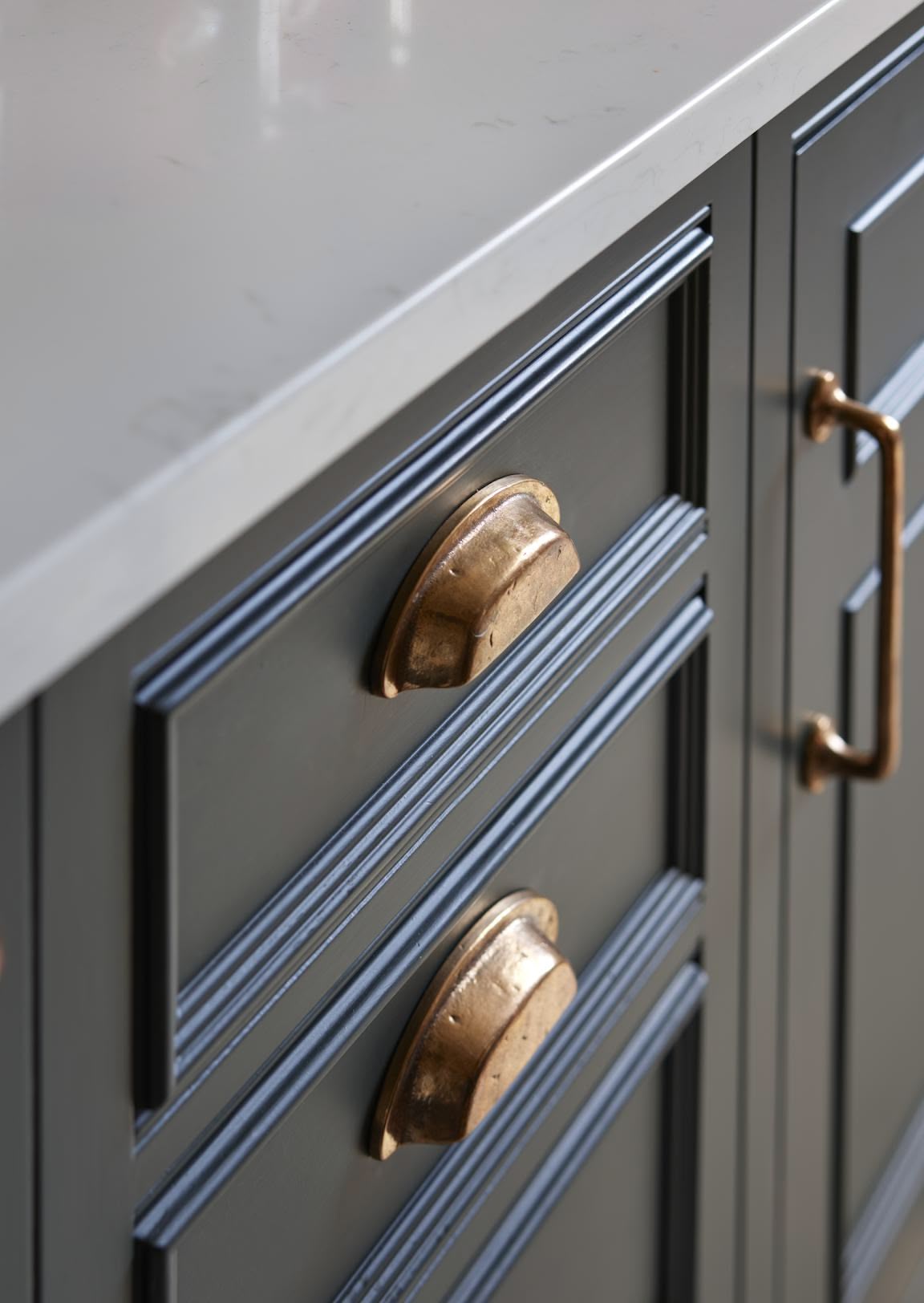 Closeup of dark kitchen drawers with copper handles