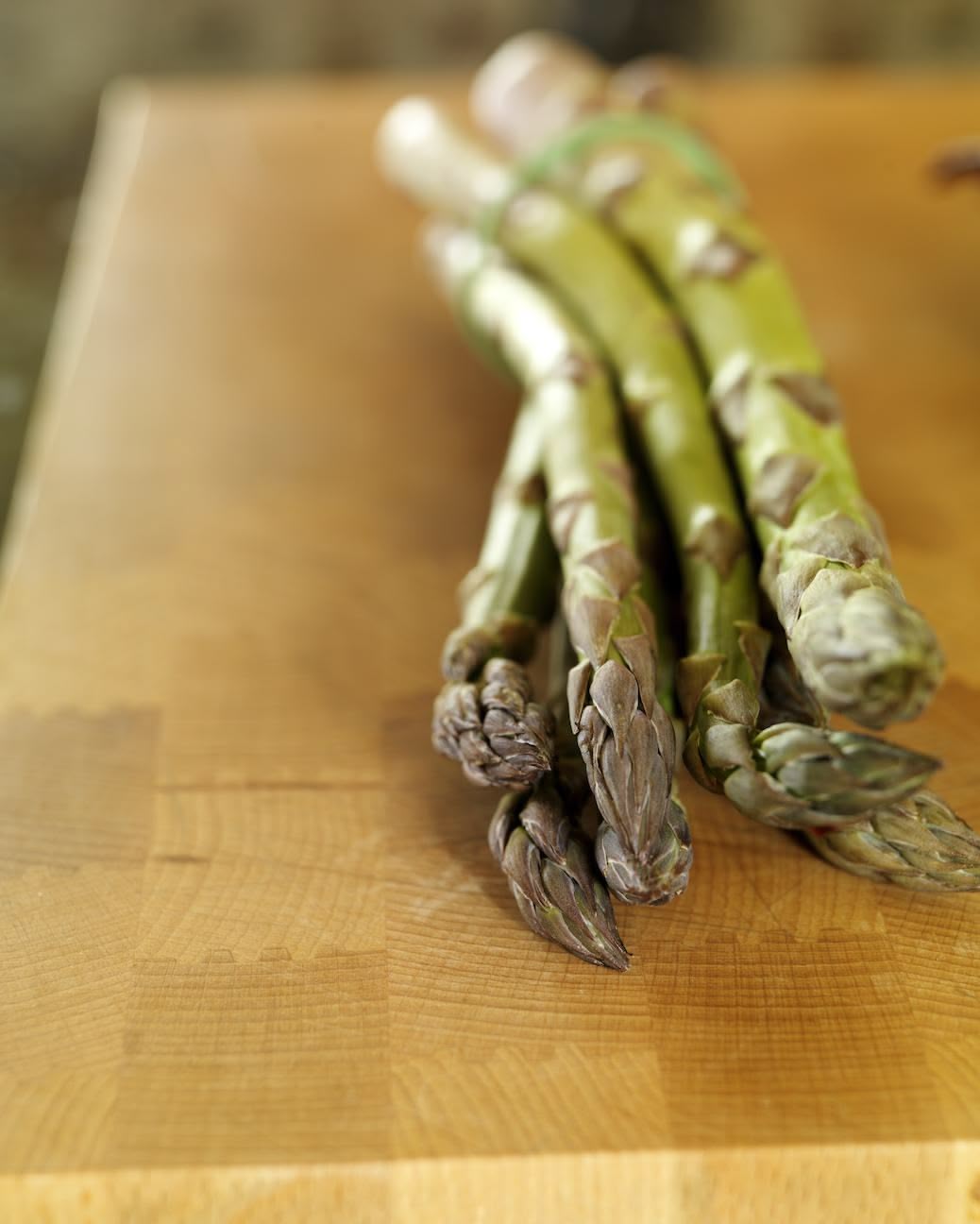 Closeup of chopping board with asparagus on Kitchen island