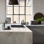 White marble end panel and worktop featuring integrated hob
