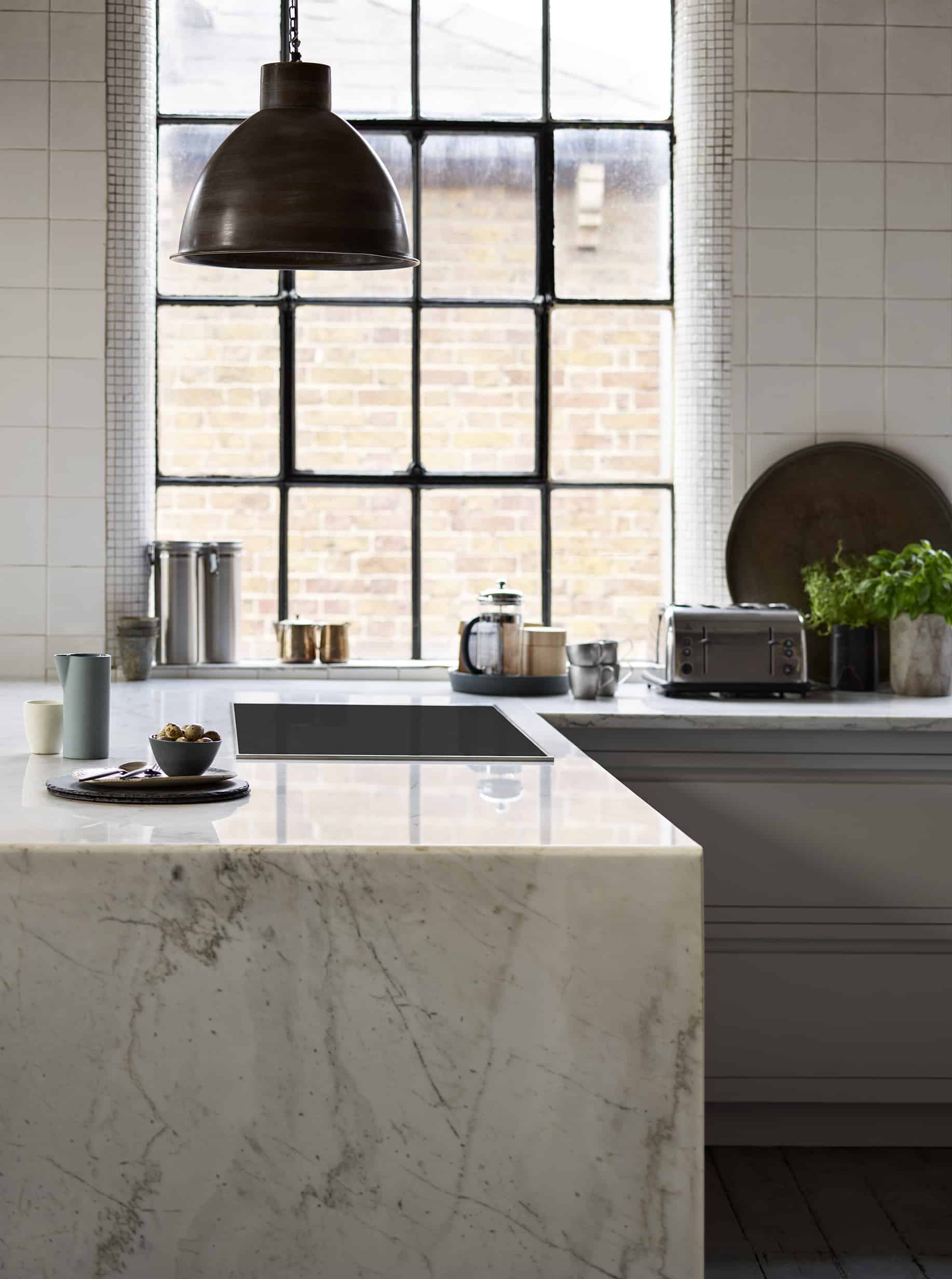 White marble end panel and worktop featuring integrated hob