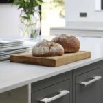 Close up of grey Linear kitchen cabinetry with light grey handles and white worktop