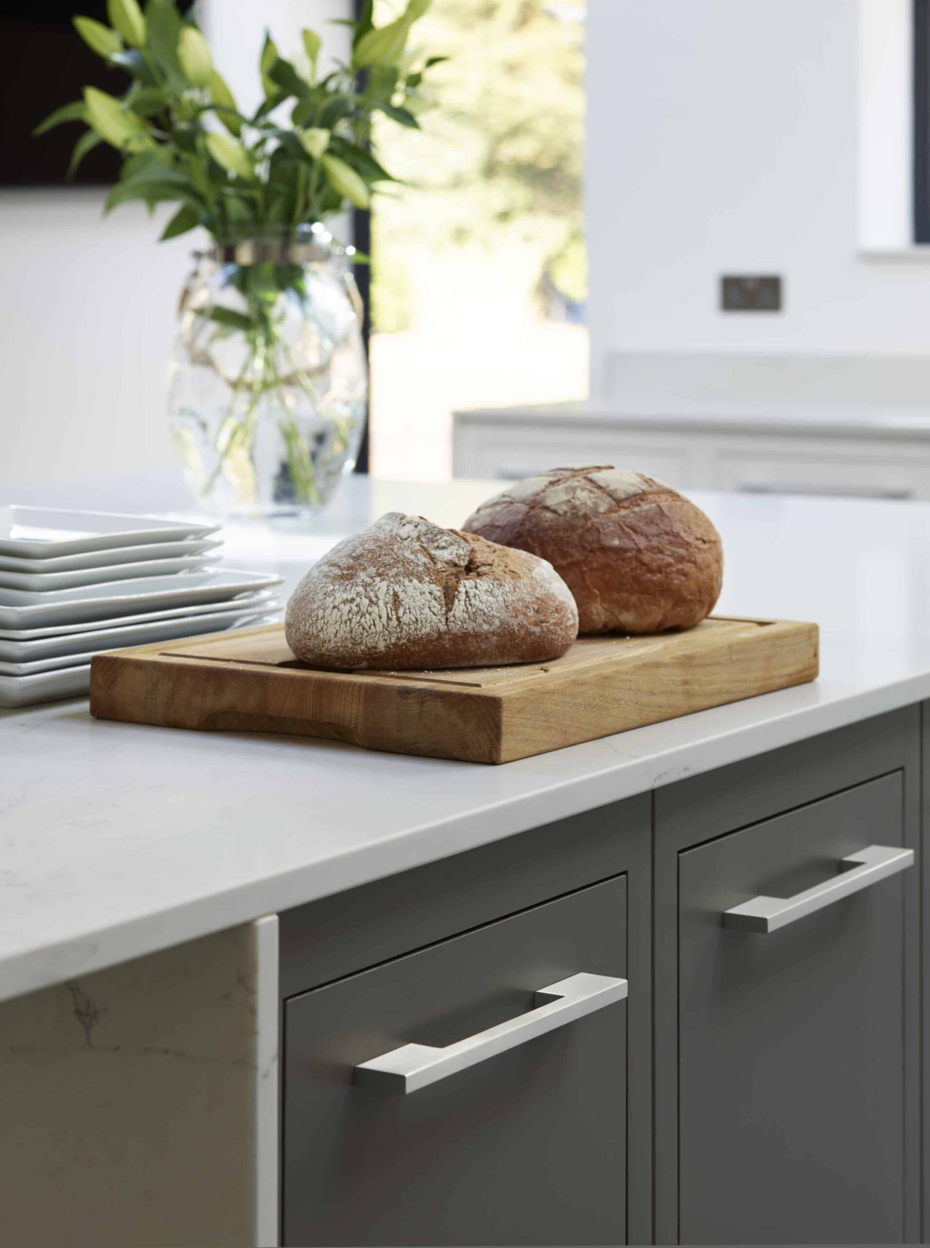 Close up of grey Linear kitchen cabinetry with light grey handles and white worktop