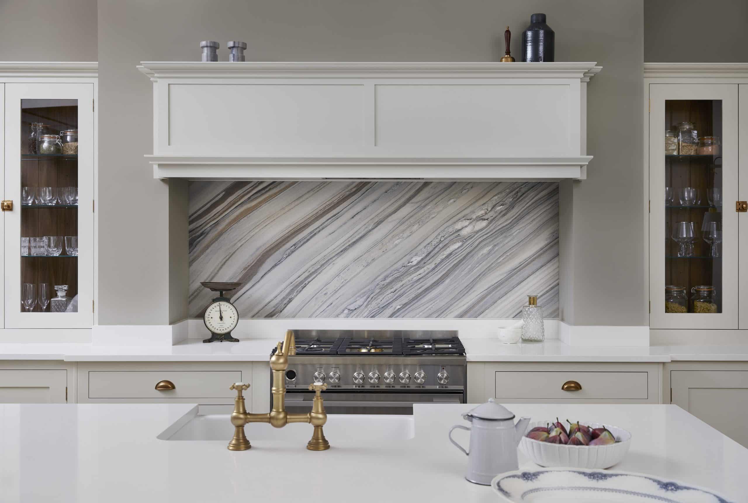 White Original kitchen cabinetry with white worktop featuring white and grey marble splashback against the cooker