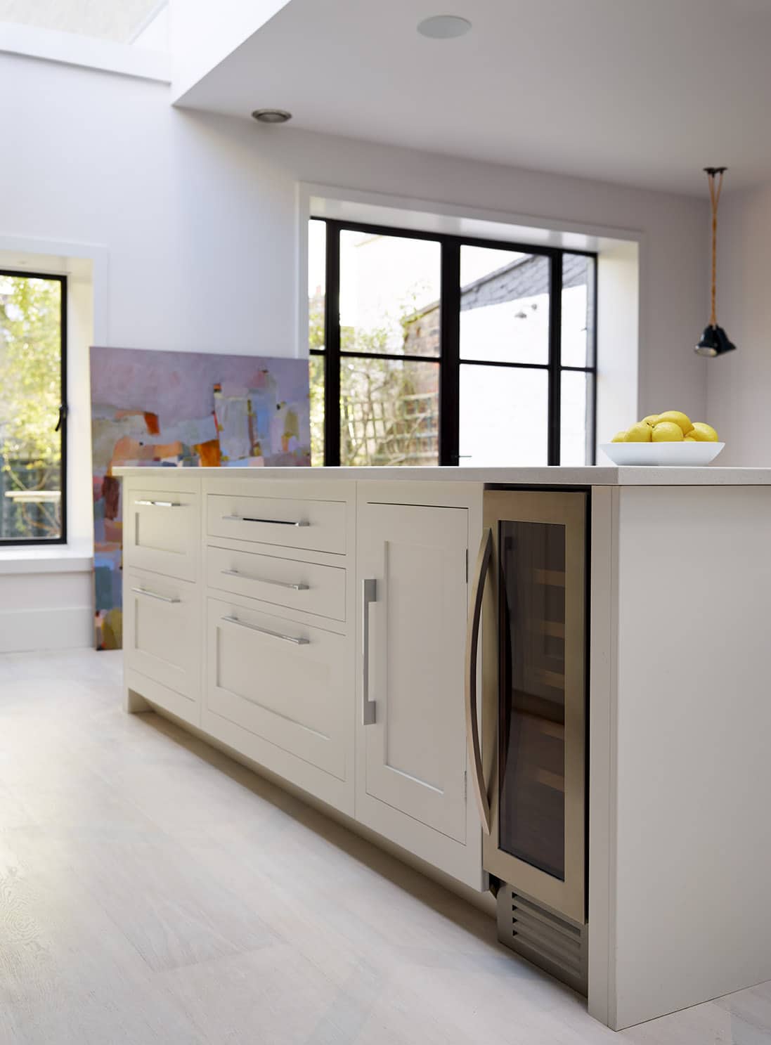 Bright white Shaker kitchen island with wine fridge