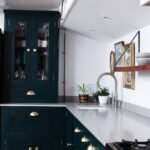 Rich green Shaker kitchen cabinetry with grey worktops