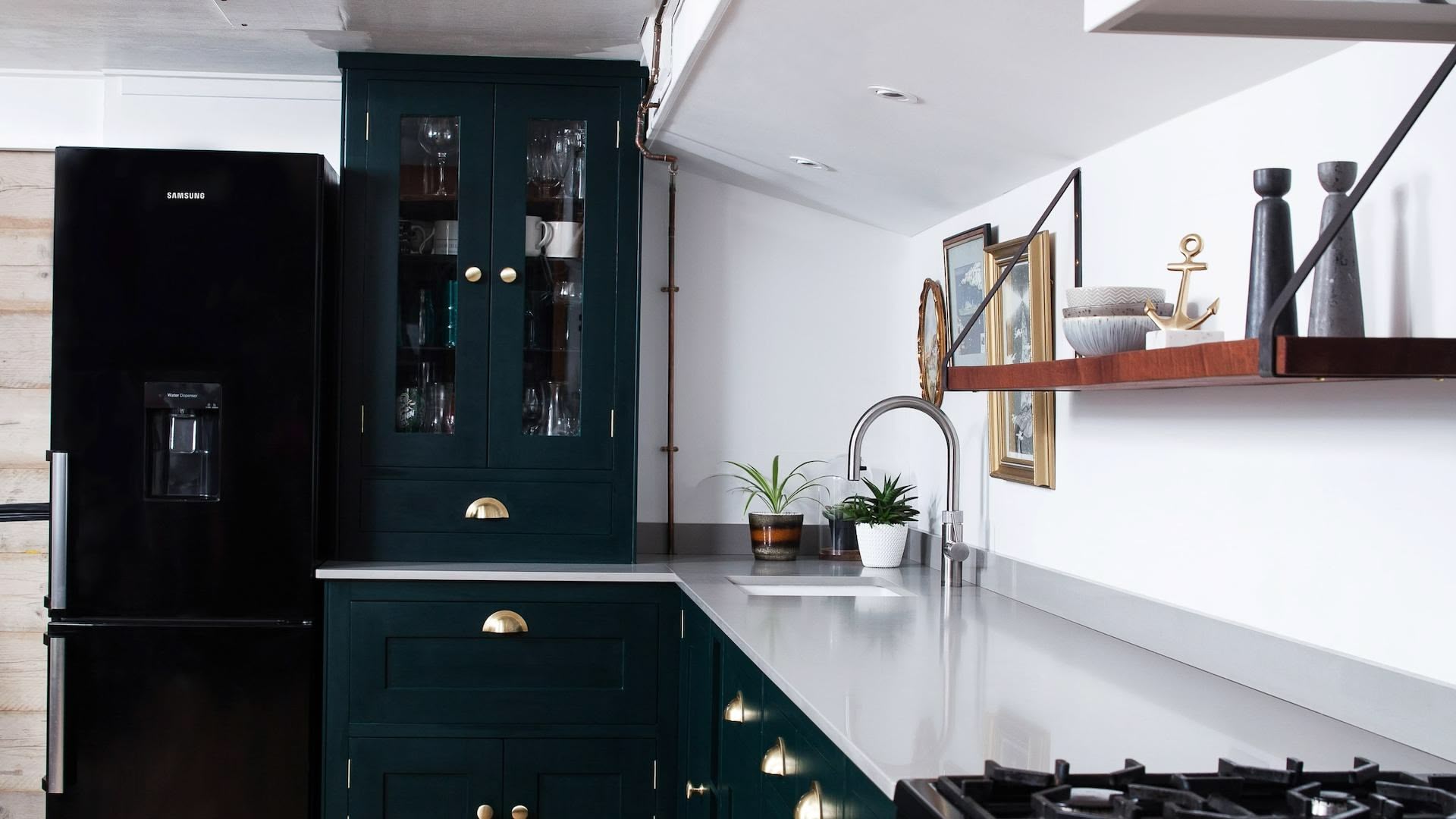 Rich green Shaker kitchen cabinetry with grey worktops