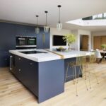 Open plan blue Linear kitchen design next to dining area