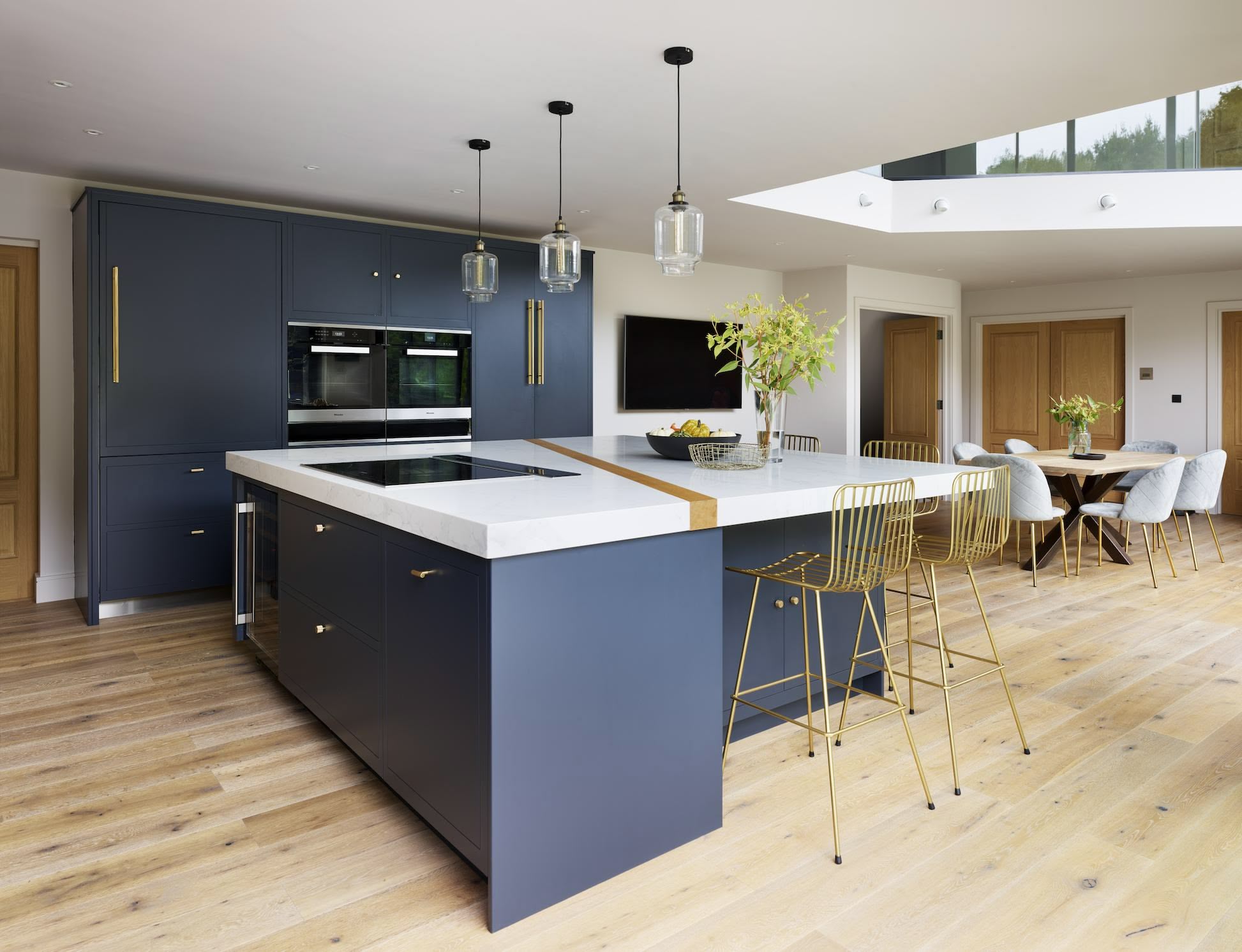 Open plan blue Linear kitchen design next to dining area
