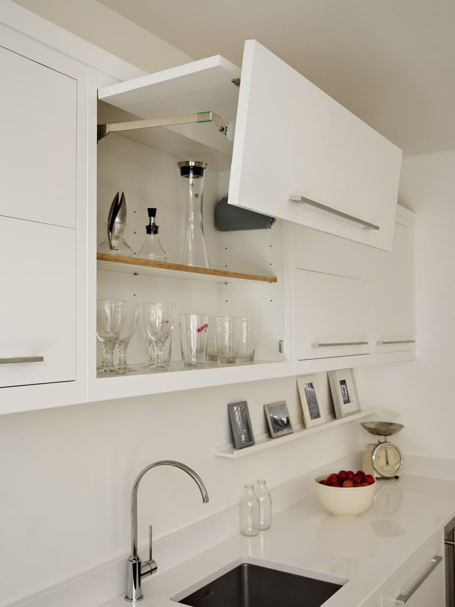 White Linear overhead kitchen cabinet open to reveal organised shelving