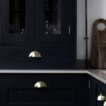 Rich green Shaker kitchen cabinetry with grey worktops