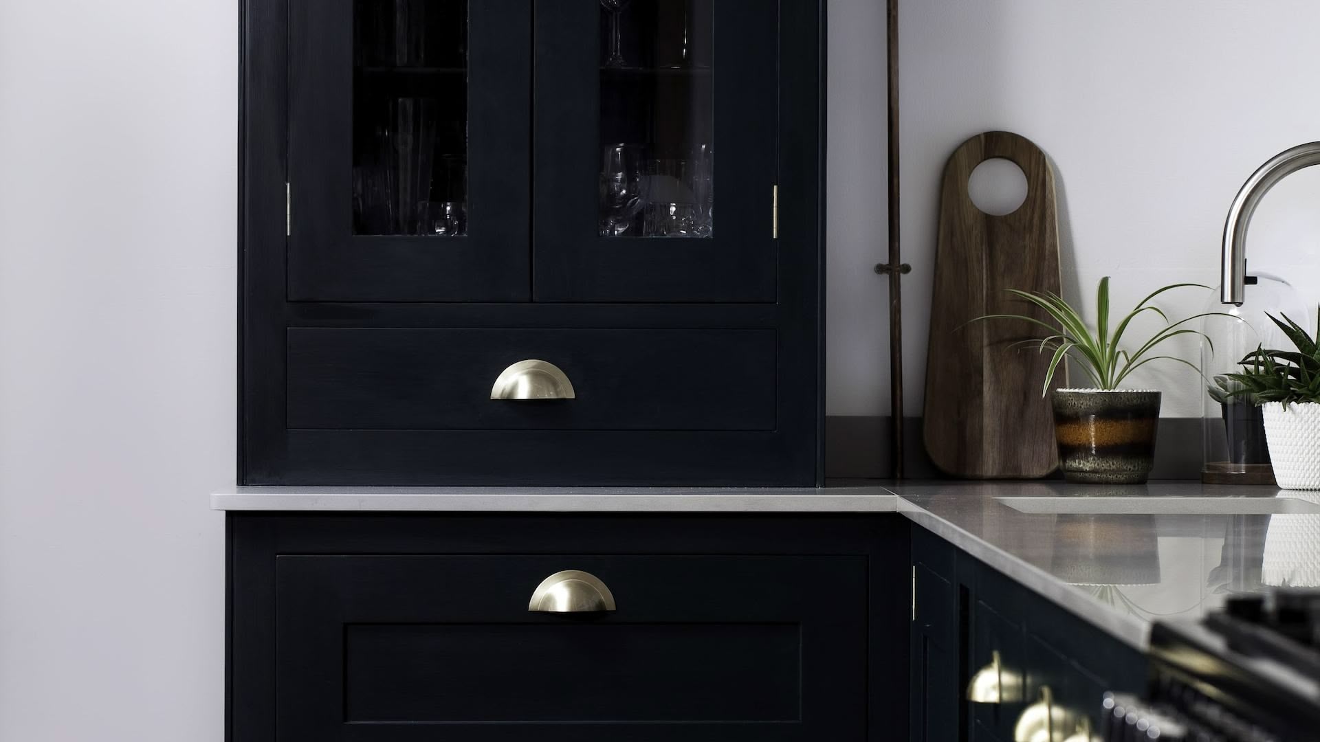 Rich green Shaker kitchen cabinetry with grey worktops