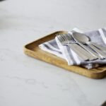 Close up of white marble worktop with cutlery on a chopping board