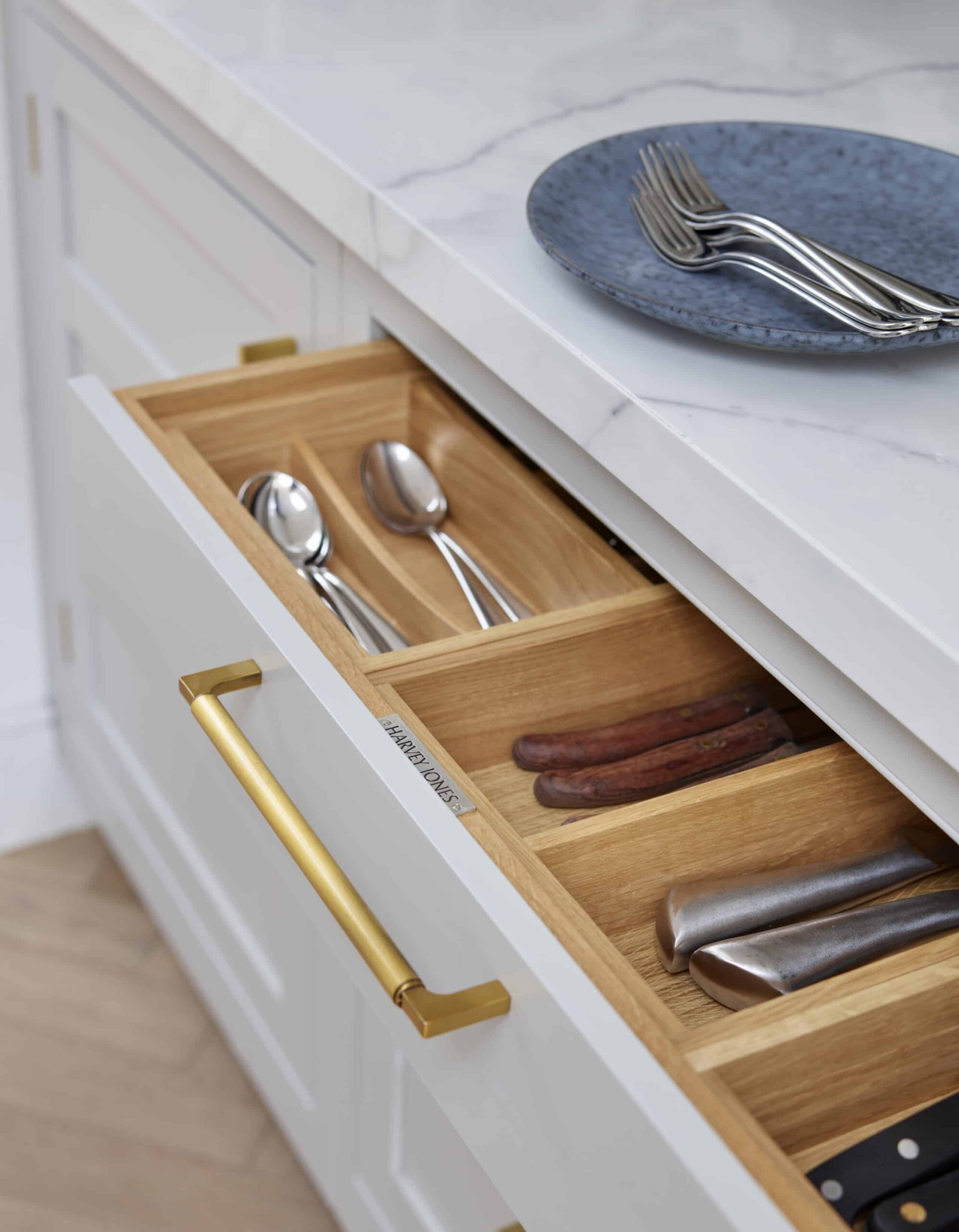 Light grey kitchen drawer with oak interior open to show organised cutlery storage