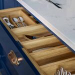 Closeup of navy Shaker kitchen drawer open to show light oak interior
