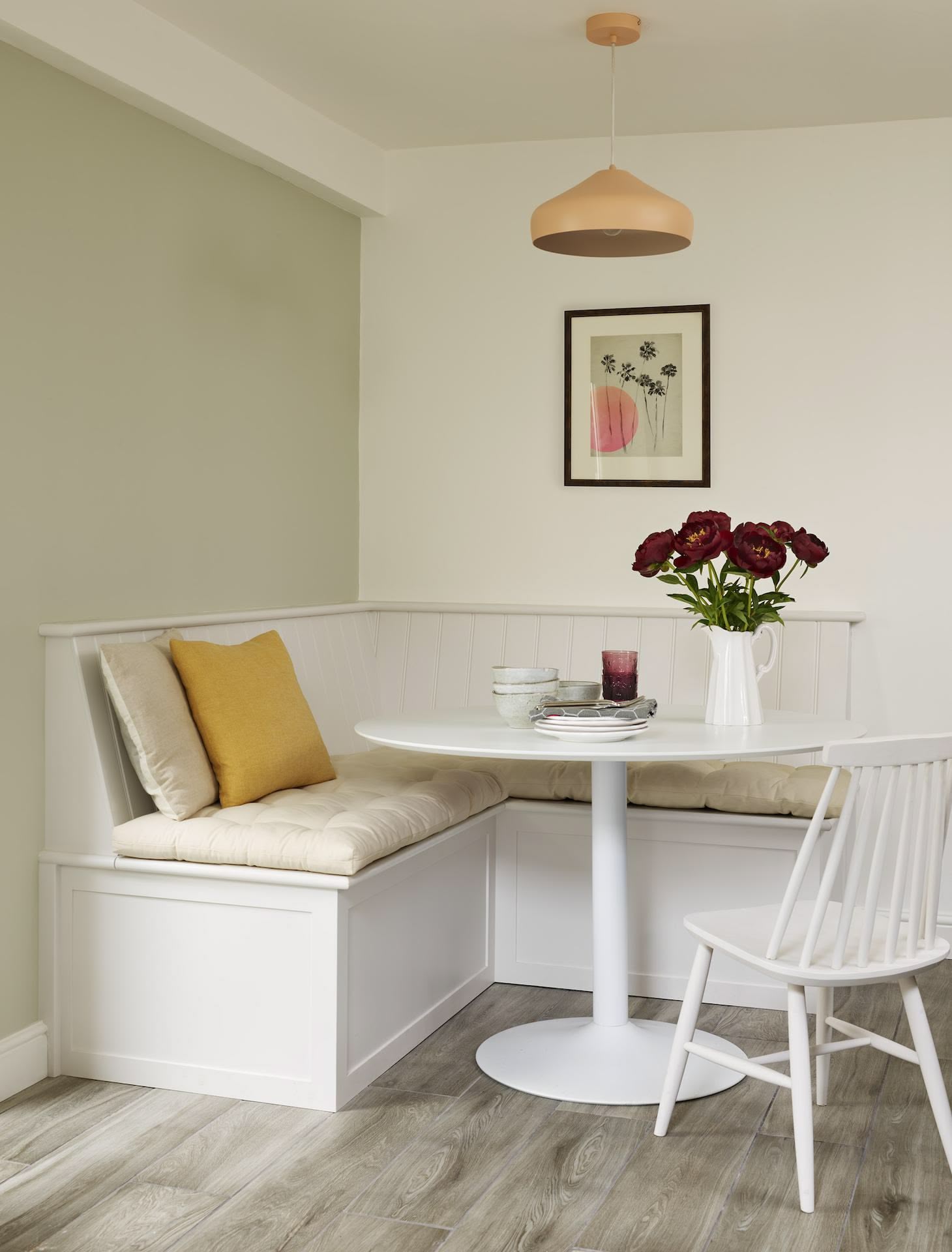 White and beige dining area featuring banquette seating