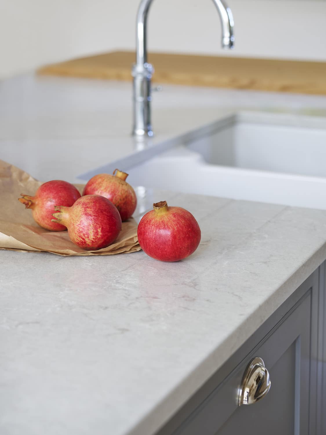 Closeup of white basin sink with silver tap next to grey marble worktop