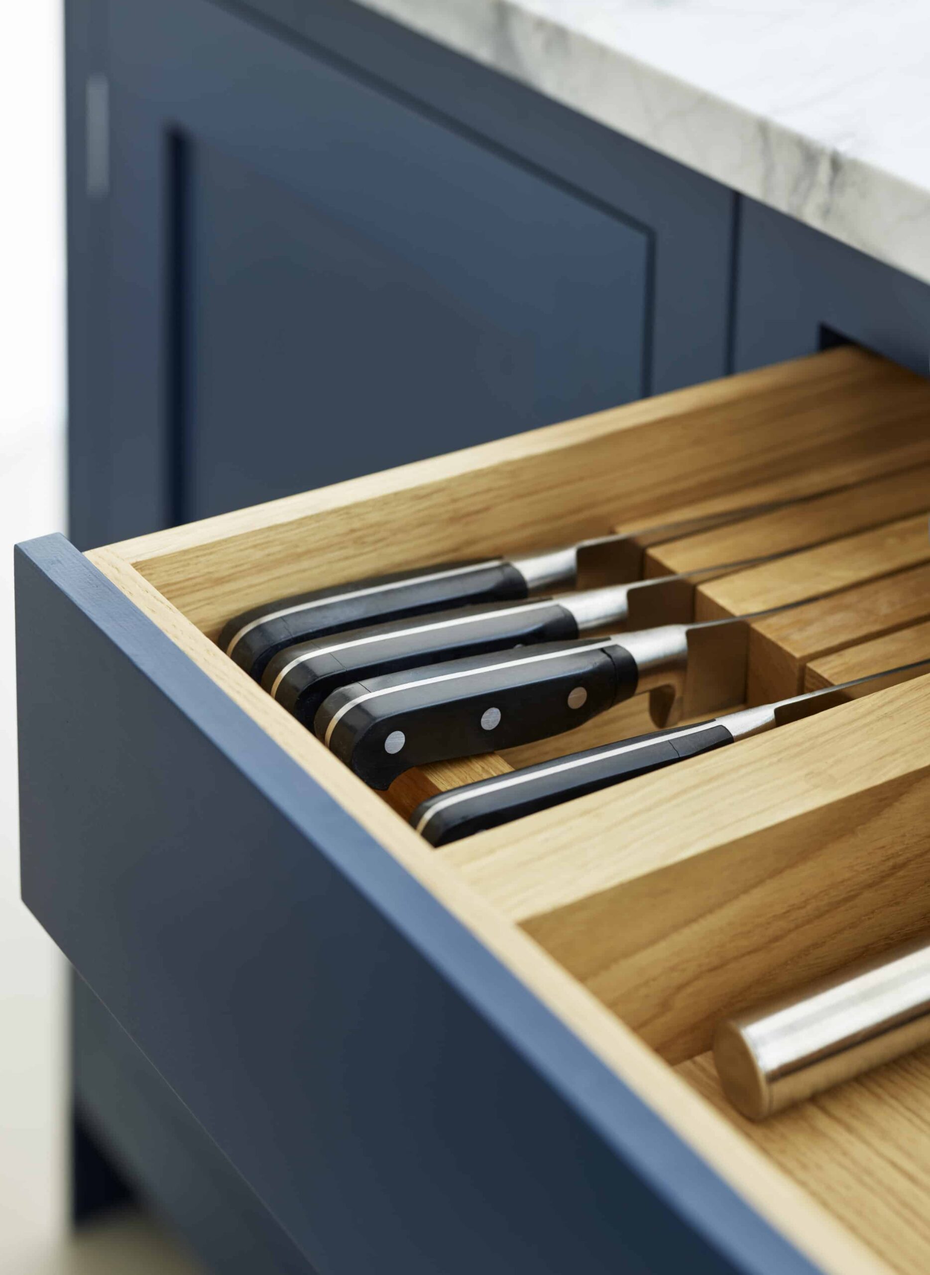Blue kitchen drawer with oak interior open to show organised cutlery storage