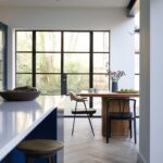 Navy Shaker kitchen island with white worktop overlooking open plan dining area