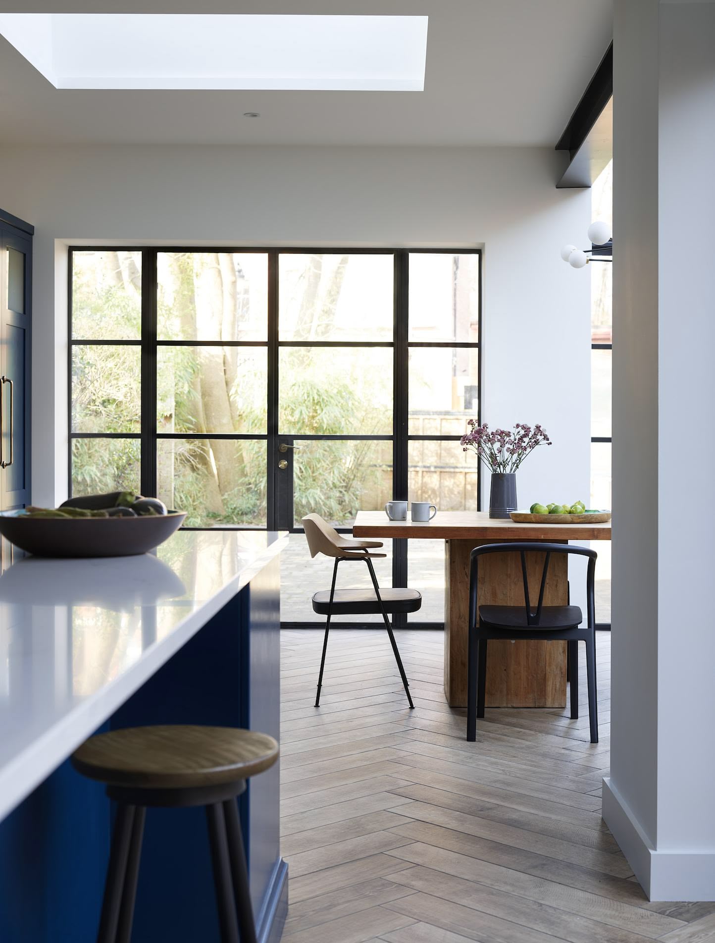 Navy Shaker kitchen island with white worktop overlooking open plan dining area