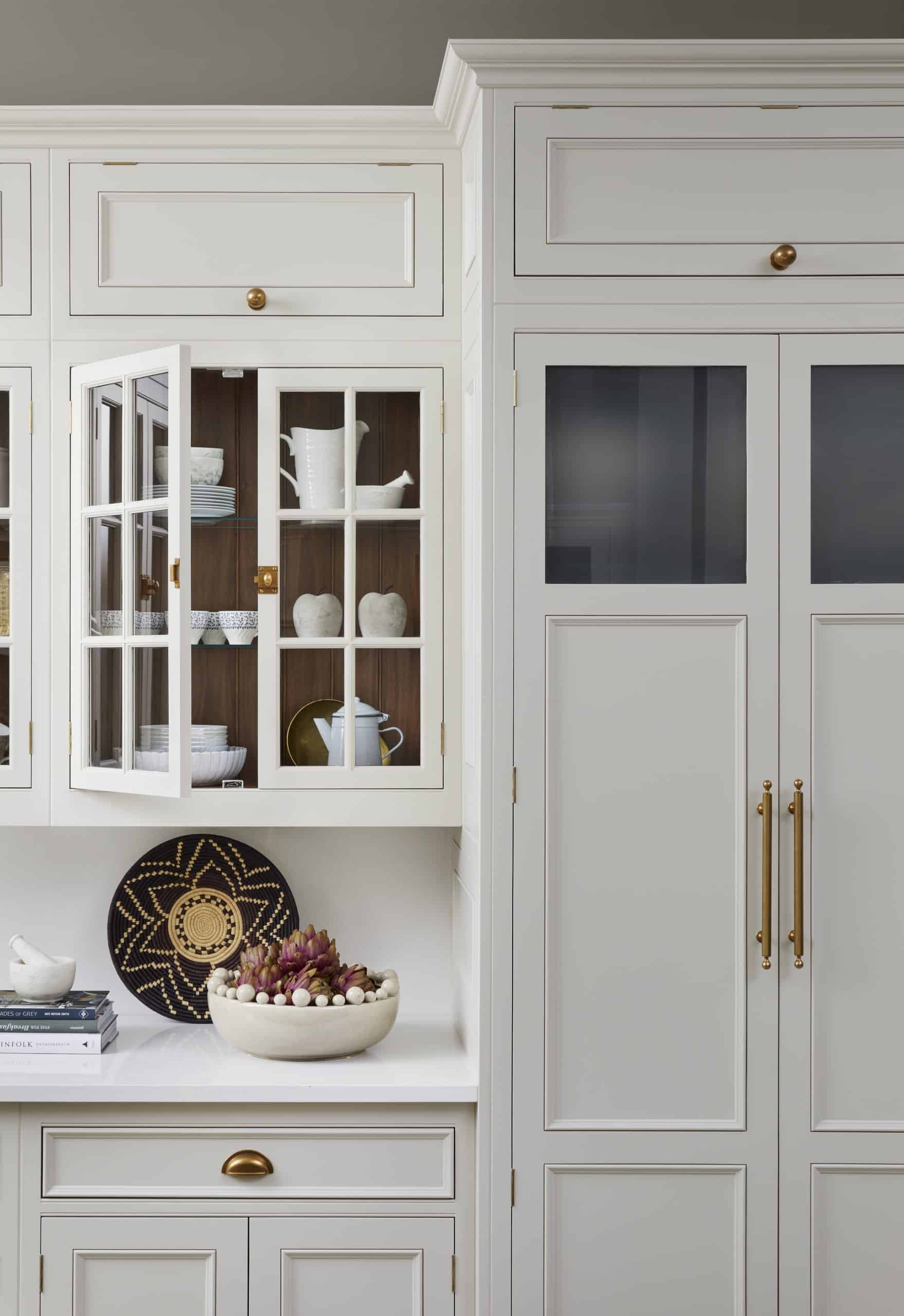 White Original kitchen cabinetry with overhead glass framed doors showing organised storage