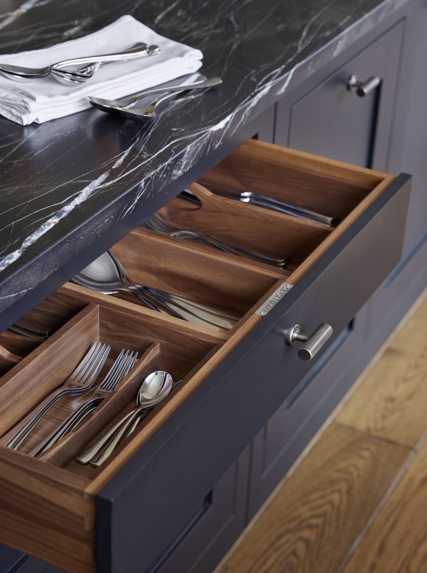 Black kitchen drawer with walnut interior open to show organised cutlery storage