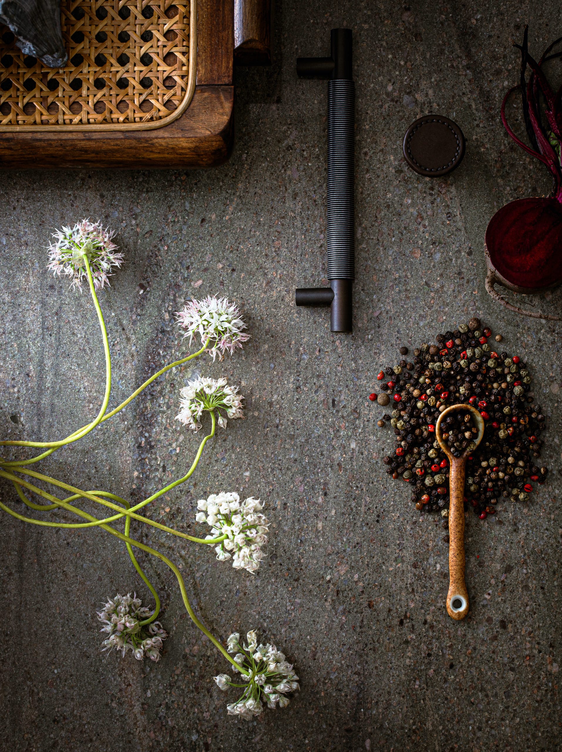 Closeup of dark granite worktop with flowers and dark cabinet handle