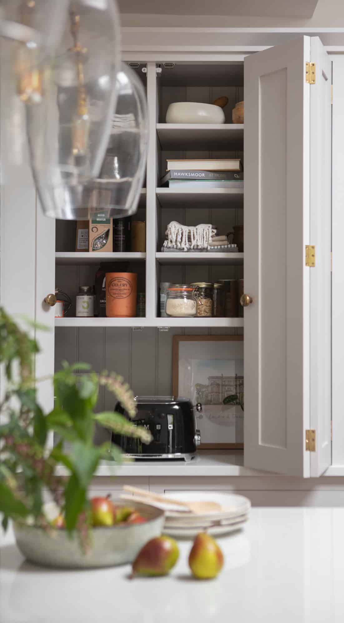 White Shaker kitchen unit open to show hidden workspace and organised shelving