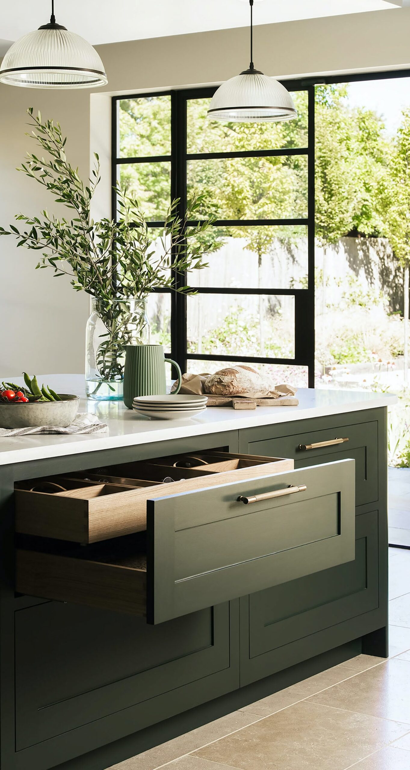 Dark green kitchen drawer open to show organised storage