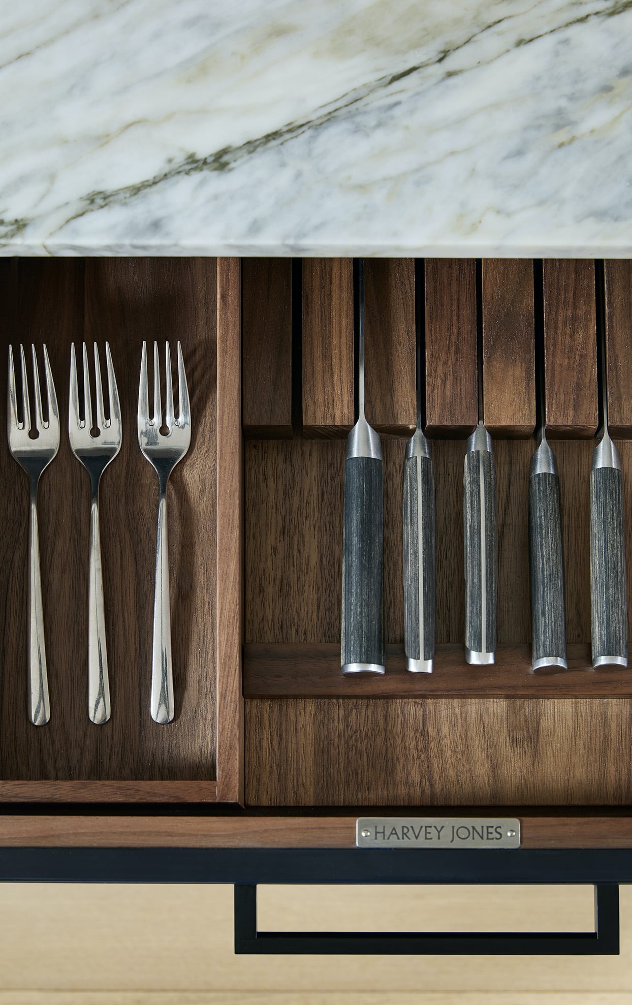 Black kitchen drawer open to show walnut interior and organised cutlery storage