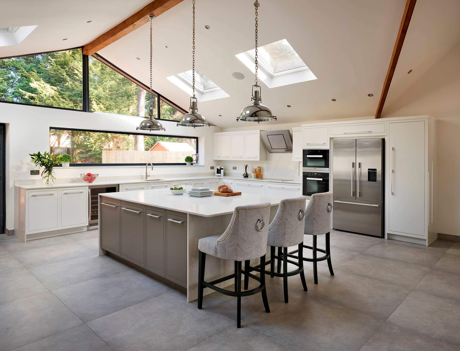 White kitchen cabinetry and grey kitchen island with white worktops