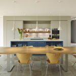 Open plan kitchen featuring blue kitchen island and dining area