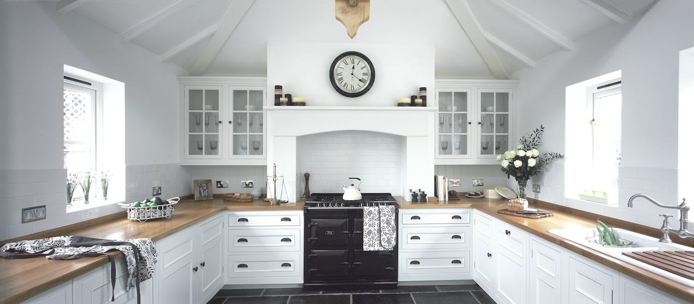 Bright white Shaker kitchen cabinetry with walnut worktops