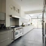 Long Linear kitchen featuring grey cabinetry and black worktops
