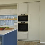 White Linear secret pantry door next to integrated appliances