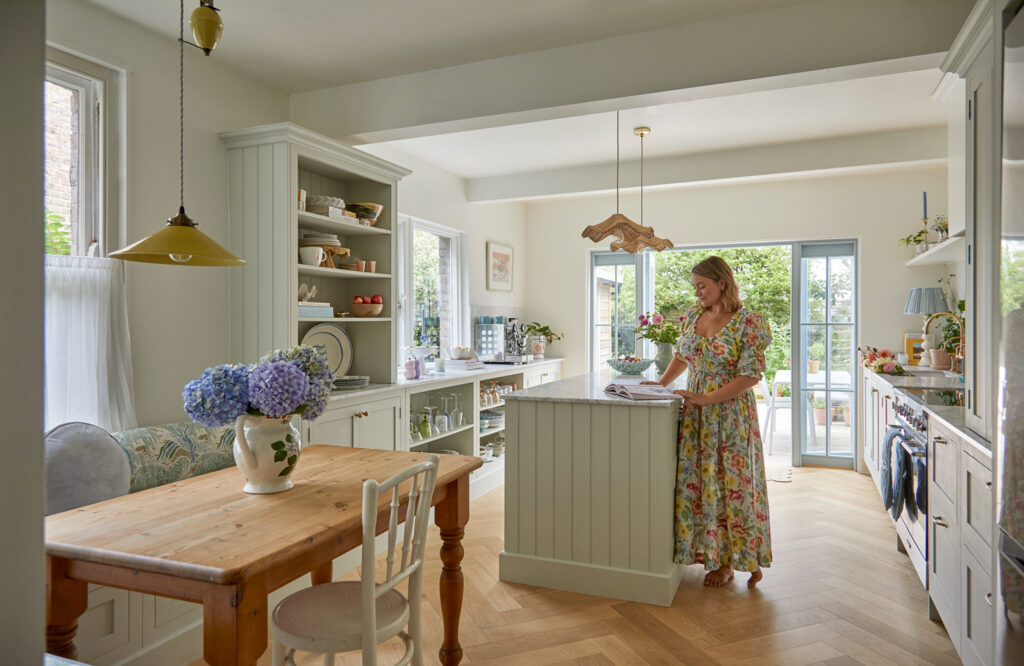 Small kitchen island with rattan lights and tongue and groove panelling detail