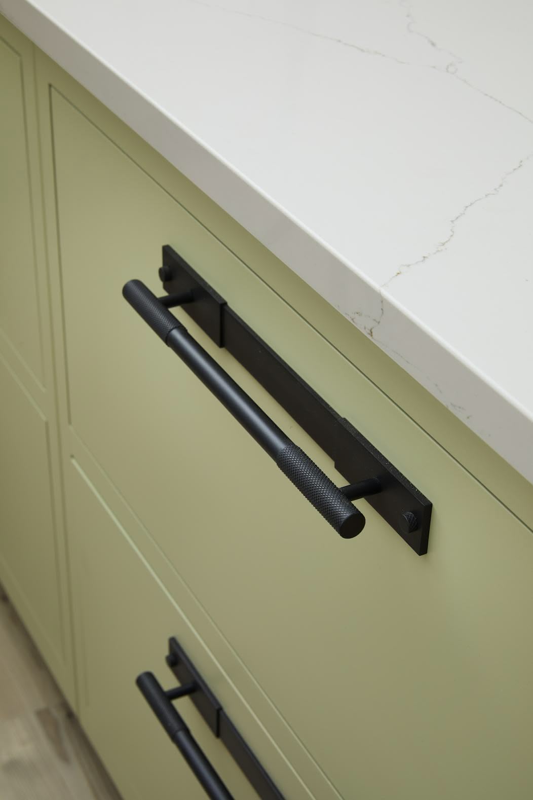 Closeup of green Linear kitchen drawers with black handles