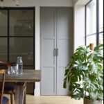 Grey Arbor pantry next to a kitchen dining area