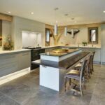 Kitchen island featuring integrated seating and grey kitchen cabinetry